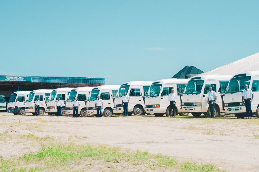 Conductores junto a una flota de buses